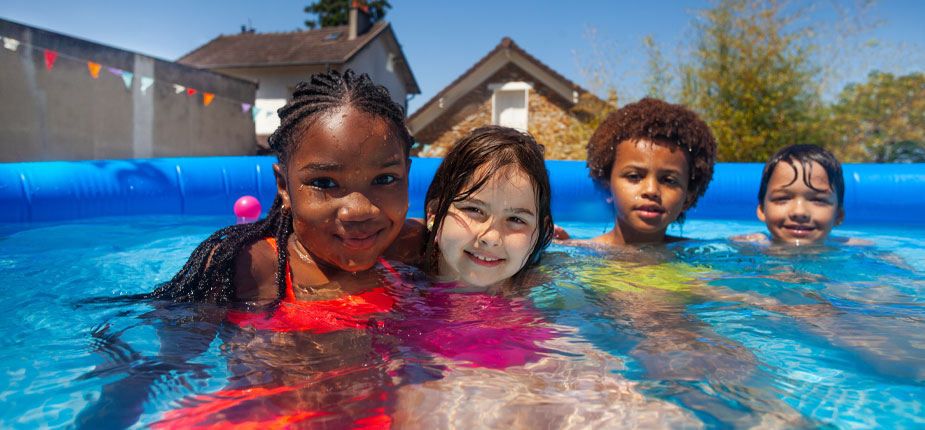 kids playing and smiling in a swimming pool